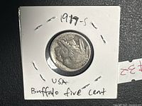 Obverse side of 1917-S Buffalo nickel coin enclosed in white cardboard holder with handwritten text '1917-s USA Buffalo five cent'.