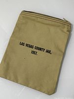 Front side of beige cloth bag showing printed text 'LAS VEGAS COUNTY JAIL, 1957.'