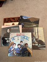 Five vinyl LP records on carpet floor.