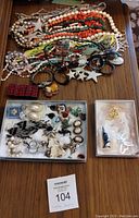 Full assortment of jewelry accessories including necklaces, bracelets, earrings and brooches laid out on table.