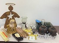 Full lot showing assortment of candles, holders, decorative angels, glass butterflies, planters, and a cross pen.