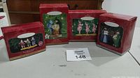 Four original boxed Hallmark Keepsake ornaments including Lullaby League, Poppyfield, Munchkinland Mayor, and Coroner