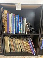 Black bookshelf with two shelves full of assorted books on history and art, titles include 'Tutankhamun', 'Egypt', 'Churches and Cathedrals', and series on ancient civilizations and architecture.