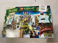 Front view of the LEGO Kingdoms Advent Calendar box showcasing the medieval winter village scene, Christmas tree, and minifigures, age range 5-12, includes 9 minifigures and 24 gifts.