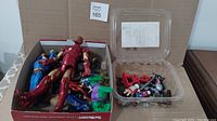 Box of mixed superhero figurines including Iron Man, Superman, Hulk, Batman, and others.