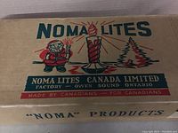 Close-up of the original Noma Lites box showing vintage Christmas graphics with Santa and candle illustration.