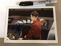 Front of the oversized trading card showing Kirstie Alley in costume on the bridge, signed in black ink.