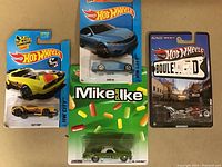Three carded Hot Wheels diecast cars including Fast Fink, BMW M4, and Boulevard series