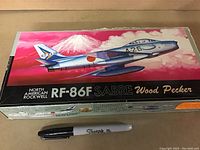 Front view of the sealed North American Rockwell RF-86F Sabre Wood Pecker model aircraft box, showing colorful artwork of the jet flying over Mount Fuji with Japanese markings.