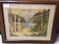 Framed art showing entire piece with totem poles and river landscape under glass