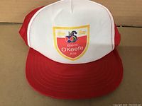 Front view of vintage red and white O'Keefe Biere Ale adjustable cap showing patch logo and overall condition.