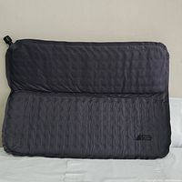 Full view of dark gray inflatable seat cushion with textured diamond pattern and Mountain Equipment Company logo.