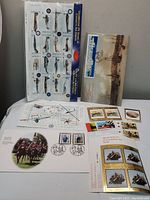 Full view of multiple stamps sheets, Day of Issue envelopes, and souvenir stamps.