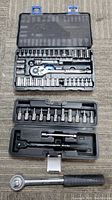 Top view showing two socket wrench sets in their original plastic cases and one extra ratchet wrench.