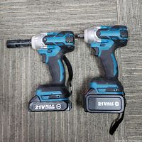 Two cordless electric ratchet wrenches side by side, showing attached 21V lithium batteries.