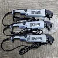 Three gray and black WORKPRO variable speed polishers/sanders laid side-by-side on a carpeted floor showing the general appearance and connected power cords.