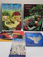 Front view of the 5 themed postage stamp sets including HO-Ho-Ho, Public Gardens, Villeneuve, Millennium, and Tall stamps with corresponding booklets and brochures.