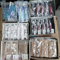 Box containing packets and boxes of various Timex, Dana Buchman, and Drone GunMetal eyewear frames, sealed in plastic.