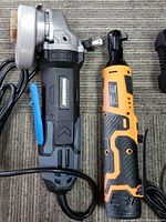 Photo of the Hammerhead corded angle grinder and Artbeisy cordless ratchet wrench side by side showing the tools and cords.