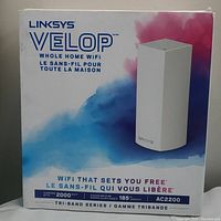 Front of box showing Linksys Velop tri-band AC2200 Whole Home WiFi router with branding and coverage of 2000 sq. ft.