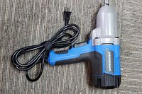 Photo of Mastercraft corded impact wrench showing overall design and power cord coiled beside it on a carpeted surface.