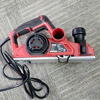 Side angle of Skil corded planer showing handle, dust port, and body with power cord