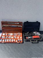 Photo shows Job Mate rotary tool in black plastic carrying case and Mastercraft accessory kit in open orange and wood case with multiple tool bits and accessories inside.