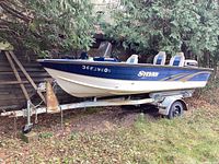 Side view of blue and white Sylvan boat mounted on trailer