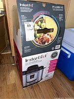 Front and side view of the Instant Pot IP-LUX60 V3 box showing the model, features, and the image of the pressure cooker.