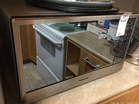 Front and side view of the Panasonic microwave oven showing its stainless steel finish and control panel.