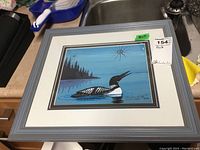 Frontal view of framed artwork showing loon on water and overall condition