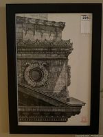 Framed black and white ink drawing showing detailed architectural elements and gargoyle faces on a building corner.