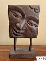 Front view of the Buddha metal sculpture showing serene face details and base.