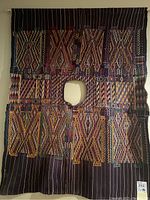 Full front view of huipil hanging on wall