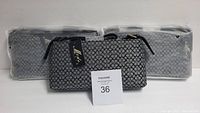 Three Moda Italia patterned purses side by side, packaged and new.