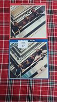 Front covers of the two Beatles albums 1962-1966 in red and 1967-1970 in blue showing the band at a balcony.