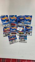 Full lot of 10 Hot Wheels cars in sealed original packages with blue themed Hot Wheels cards, arranged in roughly 3 rows.