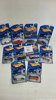 Lot of 10 Hot Wheels diecast cars in original sealed packages shown together on a white background