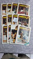 12 vintage Vancouver Canucks hockey magazines laid out on bed, showing variety of player and game shots on covers.
