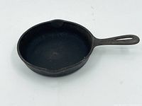 Top-down view of the cast iron skillet showing cooking surface, handle and pour spout.