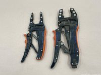Two clamping tools with orange and blue handles placed side by side, showing overall size and shape.