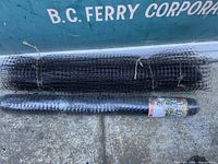 Two rolls of black wire mesh deer fencing on concrete ground against a green background with white lettering.
