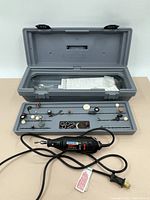 Full view of the Dremel rotary tool, its accessory trays, and gray carrying case.