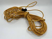 Coiled yellow vintage extension cord with black 3-prong, 3-ended outlet plug.