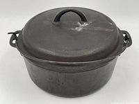 View of the large cast iron pot with the lid on, showing the rounded lid handle.