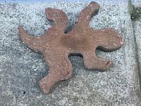 Top view of brownish-red lizard shaped concrete brick showing scale texture and lizard form.