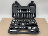 Top view of socket set case opened showing half of sockets including bits and extensions, ratchet handle in place.