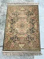 Full view of the Shaw Rugs Antiquities rectangular area rug showing central medallion and surrounding intricate floral and scroll patterns with fringed edges.