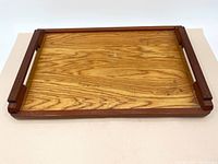 Angle view of the wooden tray showing wood grain pattern and side handles