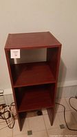 Lightly used wooden 3-shelf stand with rectangular shelves and open design.